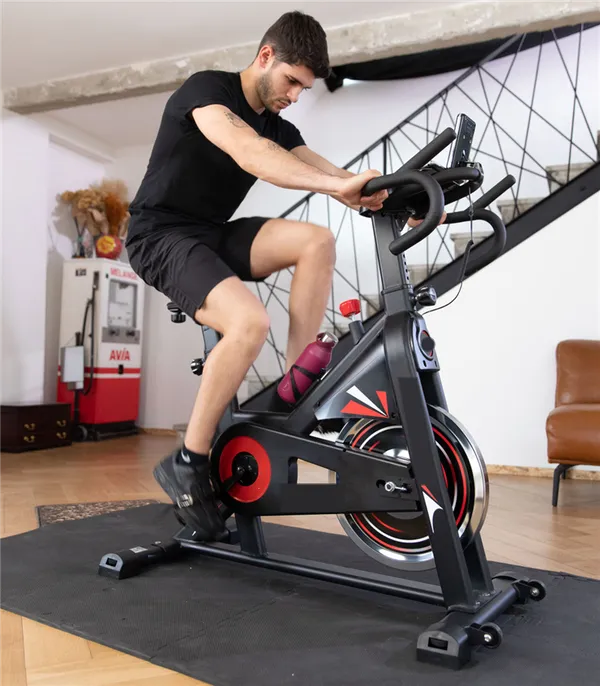 Un homme pédale sur le vélo dans son salon